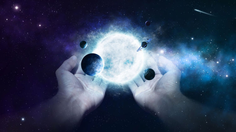 Two hands holding the sun and planets in the universe